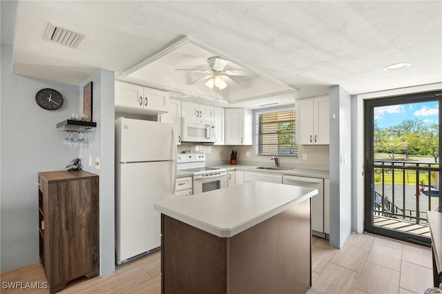 kitchen featuring visible vents, backsplash, white appliances, and white cabinetry