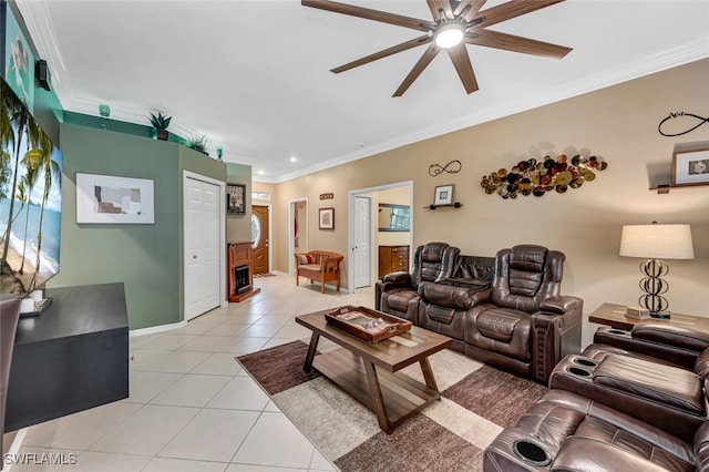 living area with light tile patterned floors, baseboards, a ceiling fan, and ornamental molding