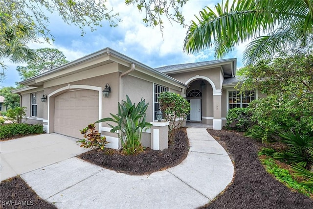 ranch-style home with concrete driveway, an attached garage, and stucco siding