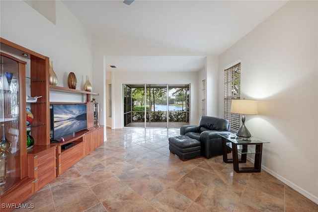 sitting room featuring baseboards and lofted ceiling