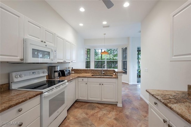 kitchen featuring white appliances, a peninsula, recessed lighting, a sink, and white cabinets