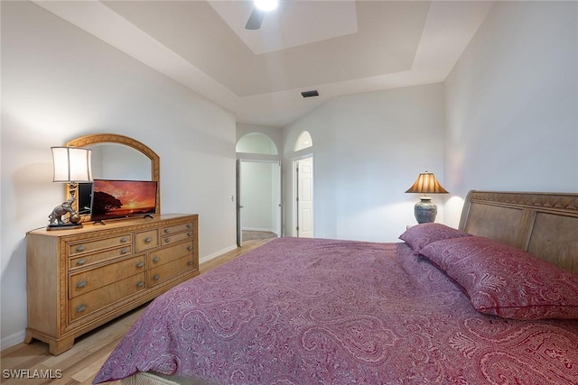 bedroom featuring light wood-type flooring, visible vents, baseboards, and ceiling fan