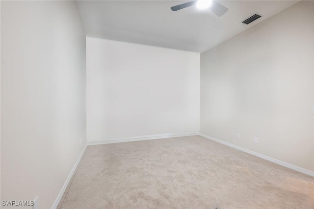 carpeted empty room featuring baseboards, visible vents, and ceiling fan