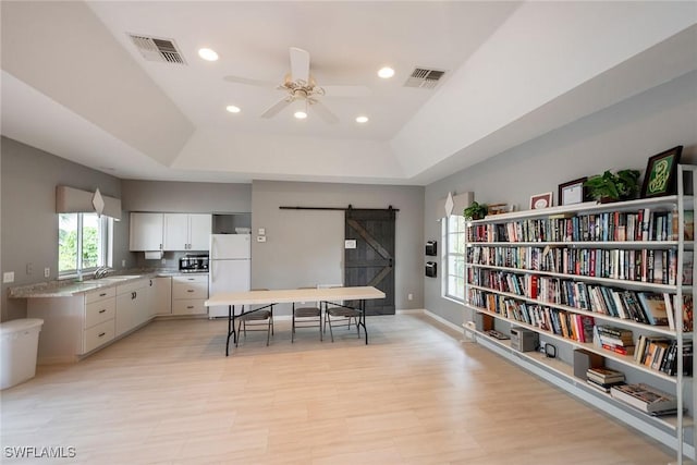 kitchen featuring a raised ceiling, a barn door, visible vents, and freestanding refrigerator