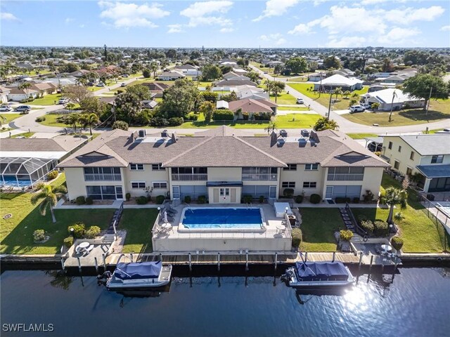 aerial perspective of suburban area featuring a large body of water and a pool