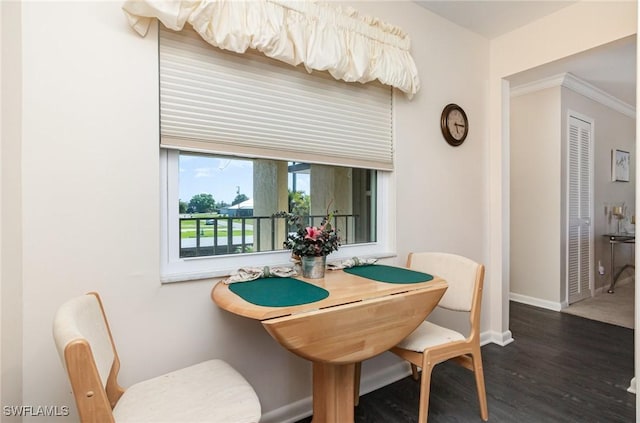 dining space featuring baseboards, wood finished floors, and ornamental molding