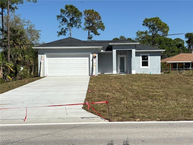 view of front facade featuring stucco siding, concrete driveway, a garage, and a front yard