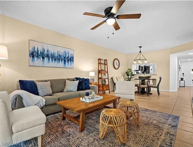 living room with light tile patterned floors, a ceiling fan, and baseboards