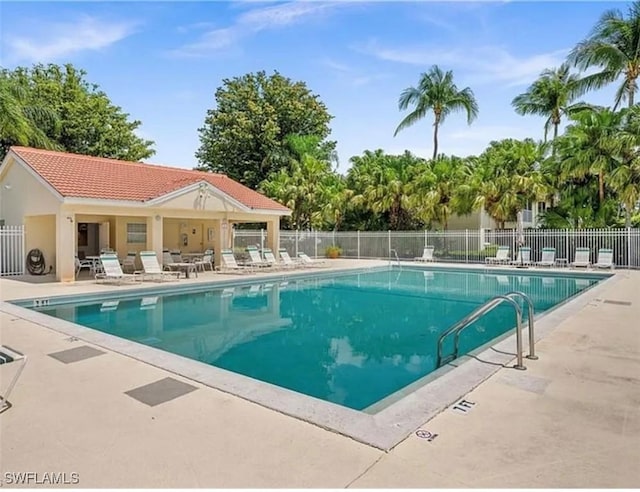 pool with a patio and fence