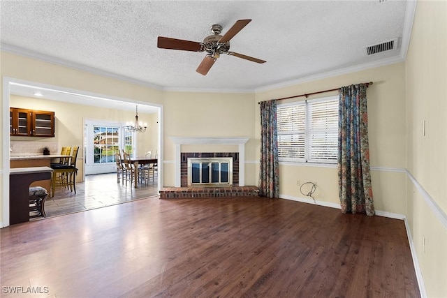 living area featuring visible vents, a brick fireplace, a textured ceiling, and wood finished floors