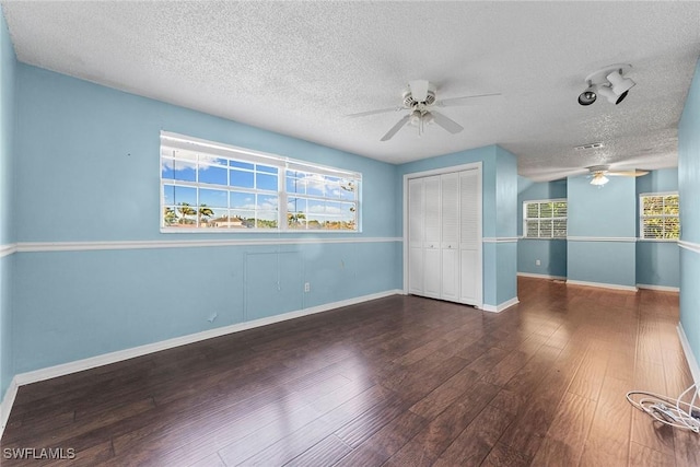 unfurnished bedroom featuring ceiling fan, wood finished floors, a closet, and baseboards