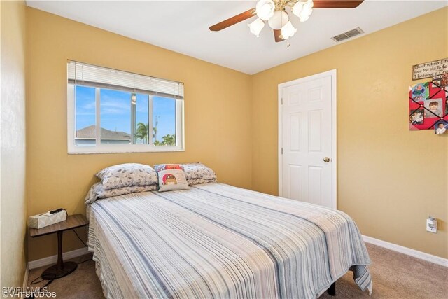 carpeted bedroom featuring baseboards, visible vents, and ceiling fan