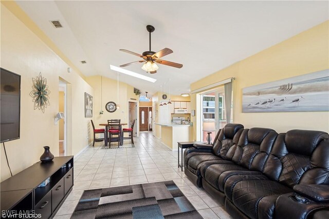 living area with vaulted ceiling, light tile patterned flooring, a ceiling fan, and visible vents