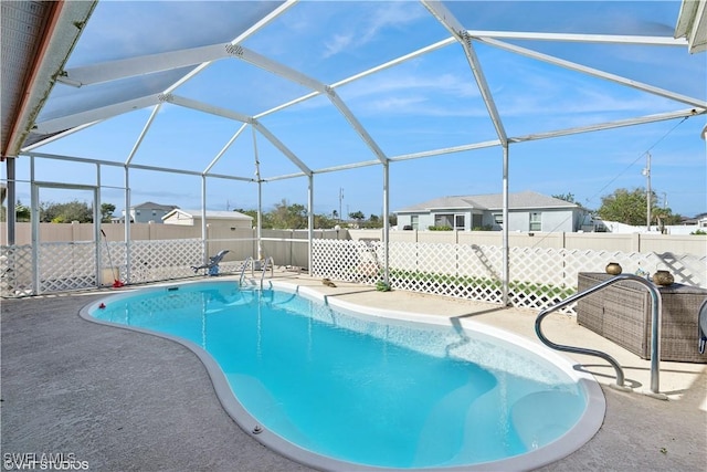 view of swimming pool featuring a fenced in pool, a patio, a fenced backyard, and glass enclosure