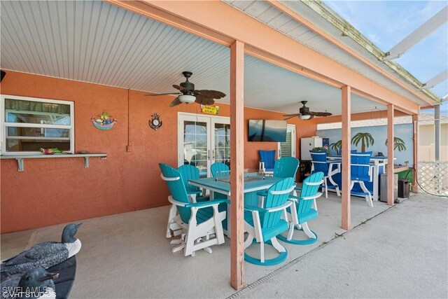 view of patio / terrace with outdoor dining space, glass enclosure, french doors, and a ceiling fan