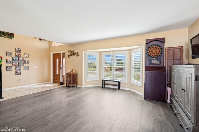 unfurnished living room featuring baseboards and wood finished floors