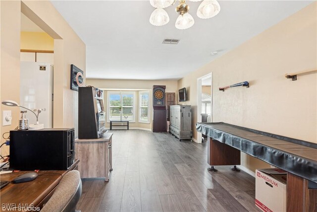 recreation room featuring visible vents, baseboards, an inviting chandelier, and dark wood-style flooring