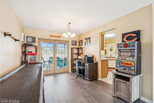 office space featuring french doors, baseboards, an inviting chandelier, and wood finished floors