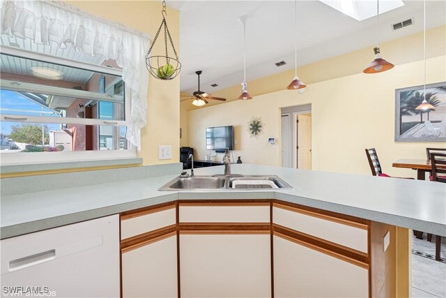 kitchen featuring visible vents, a sink, white cabinets, light countertops, and dishwasher