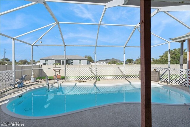 view of swimming pool with a lanai, a patio area, a fenced in pool, and a fenced backyard