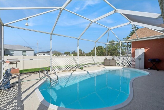 view of swimming pool with glass enclosure, a patio, fence, and a fenced in pool