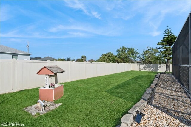 view of yard with a lanai and a fenced backyard