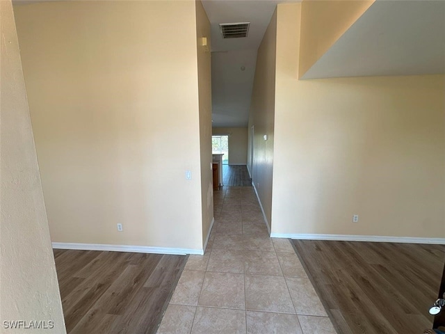 spare room with visible vents, light wood-type flooring, and baseboards