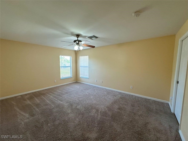 empty room featuring carpet flooring, baseboards, visible vents, and ceiling fan