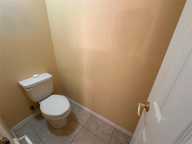 bathroom with tile patterned floors, toilet, and baseboards