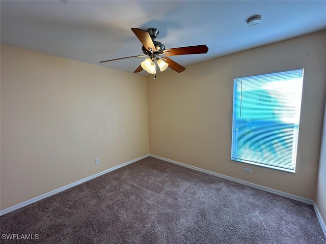 carpeted empty room featuring baseboards and ceiling fan