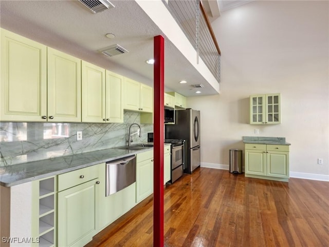 kitchen with visible vents, dark wood-style flooring, a sink, stainless steel appliances, and tasteful backsplash