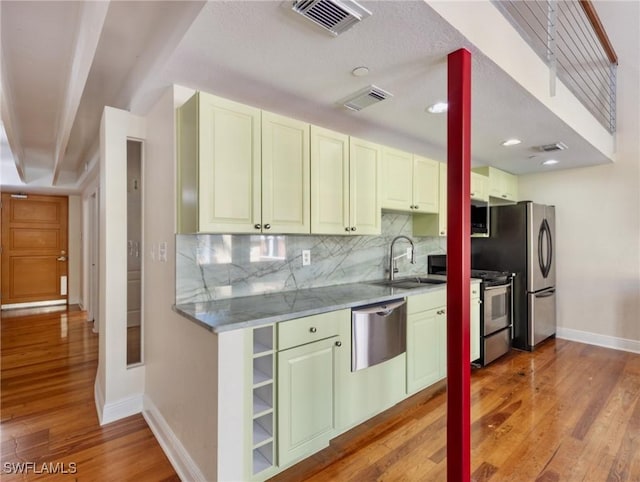 kitchen with a sink, visible vents, and light wood-type flooring