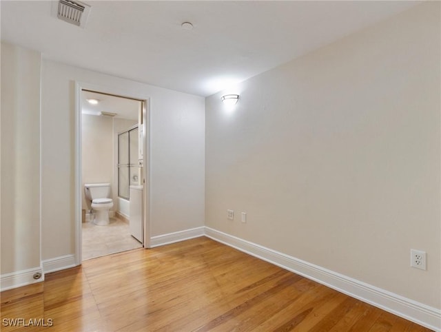 spare room featuring baseboards, visible vents, and light wood-type flooring