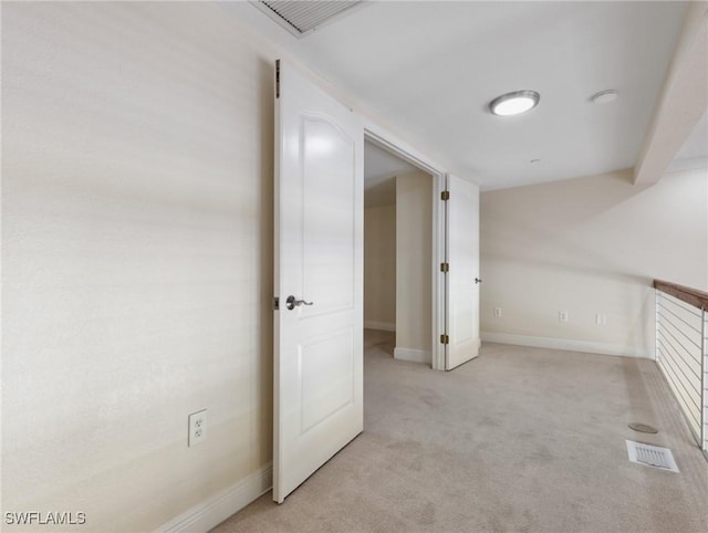 unfurnished room with visible vents, light colored carpet, and baseboards