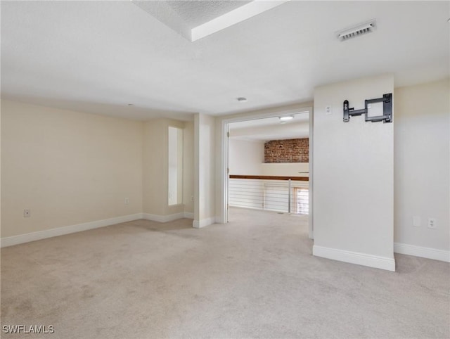 carpeted empty room with visible vents, baseboards, and a textured ceiling