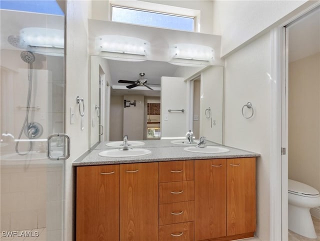 full bathroom with a stall shower, toilet, a ceiling fan, and a sink