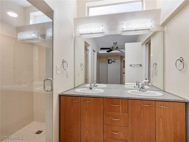 full bathroom featuring a sink, double vanity, a stall shower, and a ceiling fan