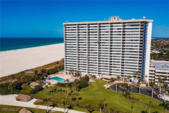 view of building exterior with a beach view and a water view