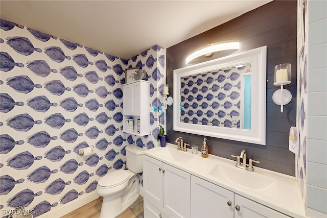 full bathroom with double vanity, wood finished floors, toilet, and a sink