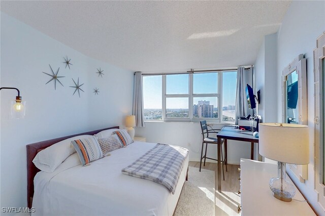 bedroom with a textured ceiling and wood finished floors