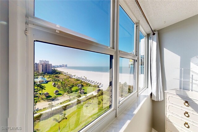 sunroom featuring a view of city, a healthy amount of sunlight, and a water view