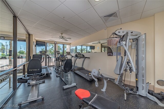 exercise room featuring visible vents, a drop ceiling, and ceiling fan