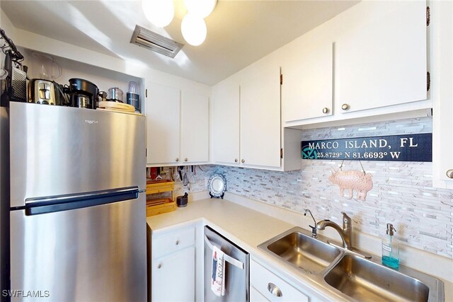 kitchen featuring visible vents, a sink, white cabinets, appliances with stainless steel finishes, and tasteful backsplash