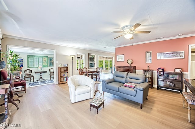 living room with ceiling fan, crown molding, and light wood finished floors