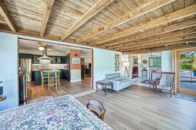 interior space featuring beam ceiling, wooden ceiling, and light wood-style floors