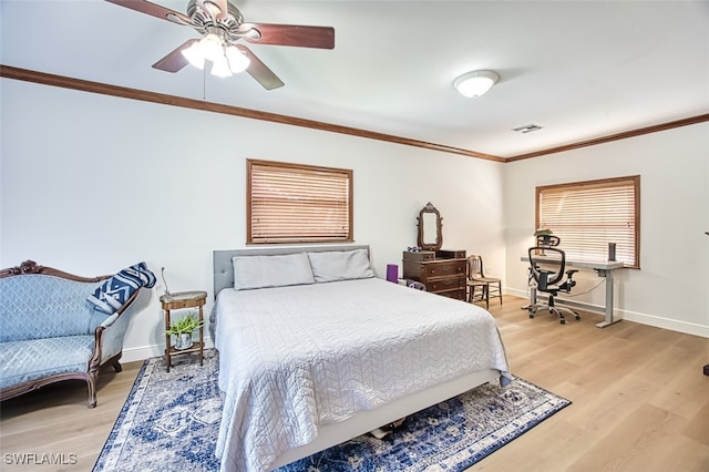 bedroom featuring crown molding, light wood-style floors, visible vents, and baseboards