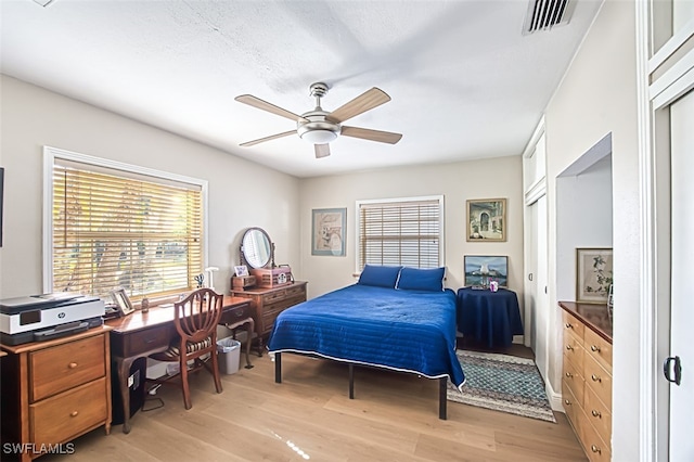 bedroom featuring visible vents, light wood-type flooring, and ceiling fan