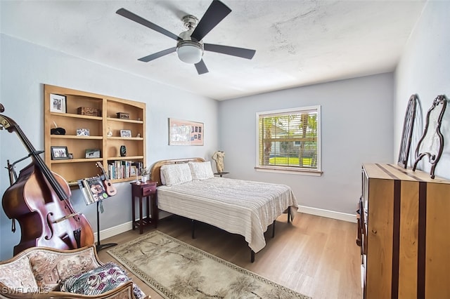 bedroom featuring a ceiling fan, wood finished floors, and baseboards