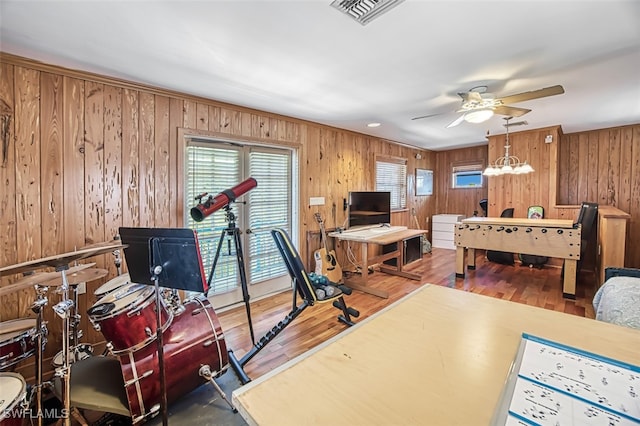 interior space with visible vents, access to outside, wood finished floors, and wood walls