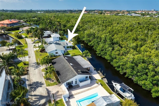 birds eye view of property featuring a forest view and a water view